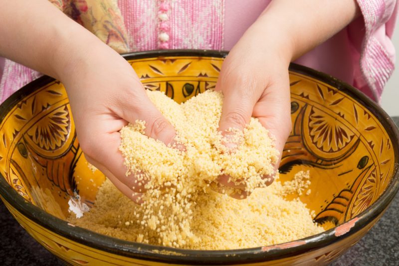Traditional Moroccan immigrant woman in Europe cooking couscous during Ramadan