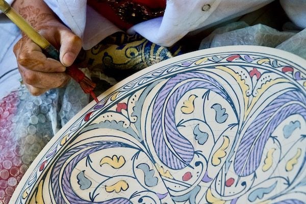 Une femme peinte au henné peint la poterie de fès à art et naji dans l'ancienne médina de fès de fas maroc