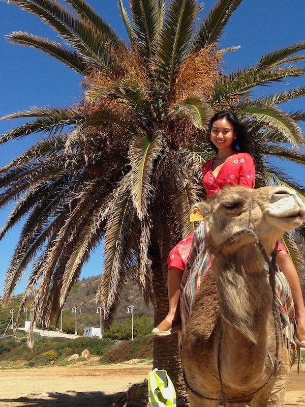 girl in a pink kaftan on a camel in Morocco
